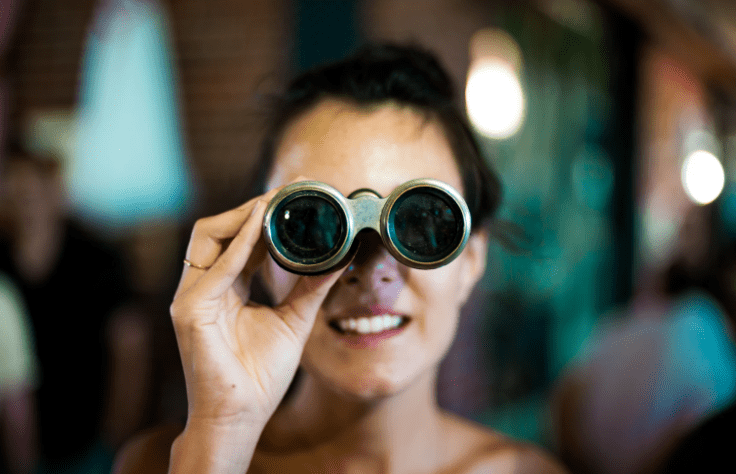 a woman looking through a pair of binoculars