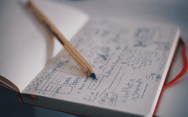 a pencil and doodles on a notebook