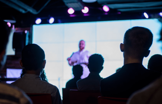 A male presentor is on stage